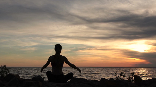 海滩日落时练习瑜伽的女人[去练]视频