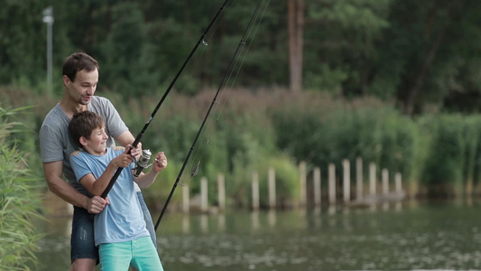 男孩和父亲在湖边钓鱼亲子时光[继父]视频