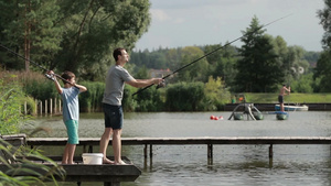 中年男子和小男孩在池塘边钓鱼30秒视频