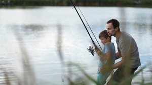 在湖边父亲帮助儿子钓鱼17秒视频