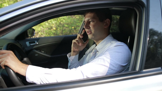 年轻商业高管坐在车里拿着手机交谈视频