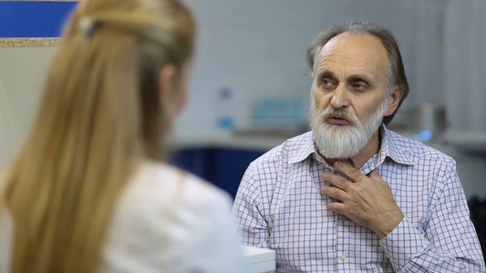 老年男性病人在医务处看医生向女医生解释他的症状视频