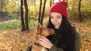 秋季户外抱着可爱的狗的美丽女人26秒视频