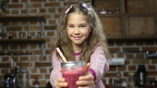 小女孩手捧美味的红色浆果冰沙视频