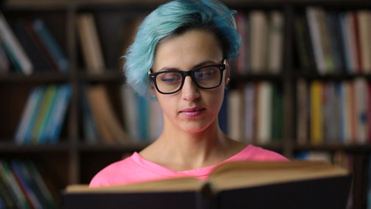 女学生戴着时髦的眼镜在大学图书馆看书视频