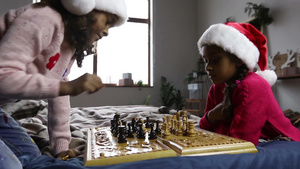 两个小女孩戴着圣诞帽在棋盘下棋13秒视频