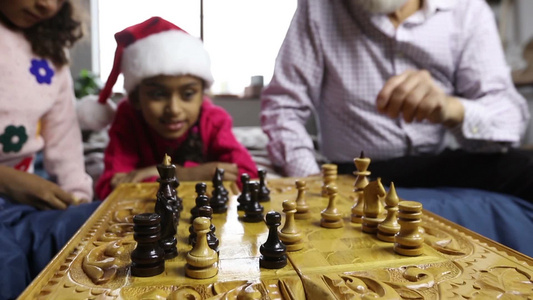 可爱的小孩子在圣诞节和她的祖父下棋视频