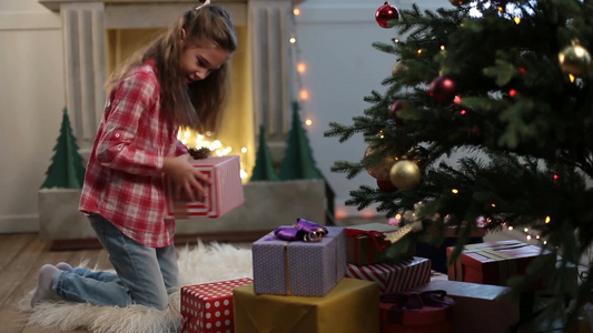 可爱的小女孩早上跑到圣诞树下开始寻找礼物视频