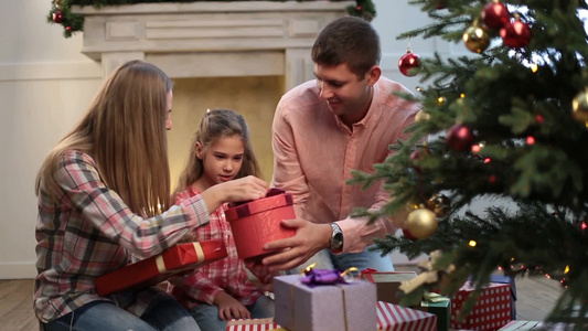 一家人在圣诞树前交换礼物视频