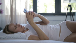 清晨年轻女性躺在床上浏览手机17秒视频
