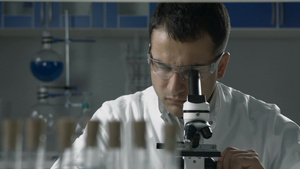 英俊的男性科学家在实验室中进行显微镜分析21秒视频
