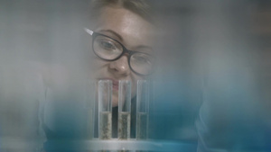 化学实验室里的女科学家在看试管溶液反应10秒视频