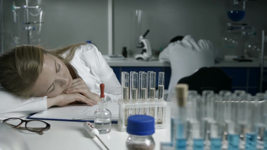 疲倦的研究人员在实验室睡觉醒来继续工作视频