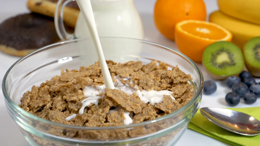 把牛奶倒在谷类薄片上做健康的早餐视频