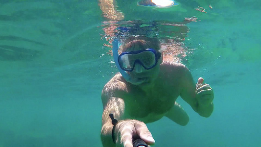 年轻人在清澈的海水中驾驶浮潜视频