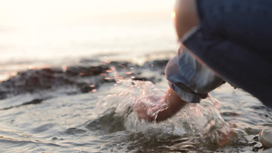 一个小女孩在海边泼海水慢动作21秒视频