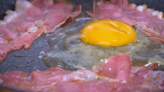 鸡蛋和培根片在热锅里煎鸡蛋缓慢地落在煎好的培根上视频