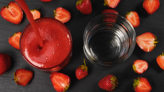 新鲜草莓冰沙在玻璃杯中流动准备饮用视频