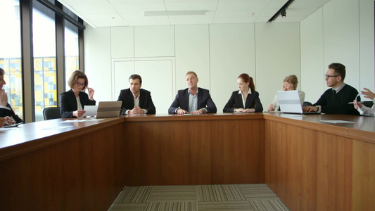 商务人士在公司会议上围坐在桌子旁聊天视频