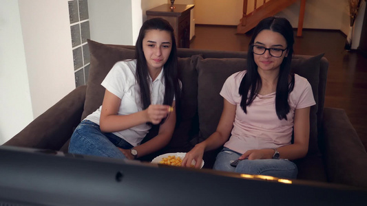 女孩们在家看电视和吃爆米花视频