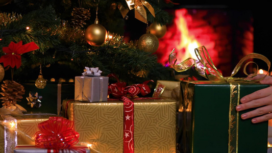 女人在壁炉附近的圣诞树下放置礼物视频