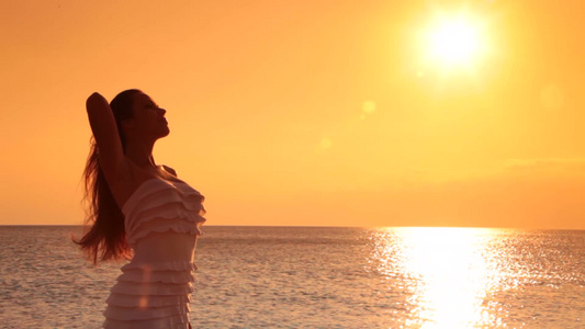 女人在海边享受日落视频