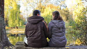 一对夫妇坐在湖边的长凳上拥抱13秒视频