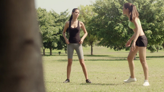两位美丽的年轻女性在城市公园跑步和做运动后伸展肌肉视频