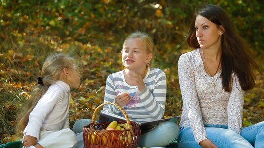 年轻的母亲和两个女儿在公园野餐视频