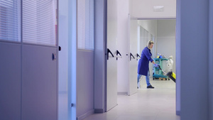医院病房外用吸尘器打扫清洁地板的女工人29秒视频