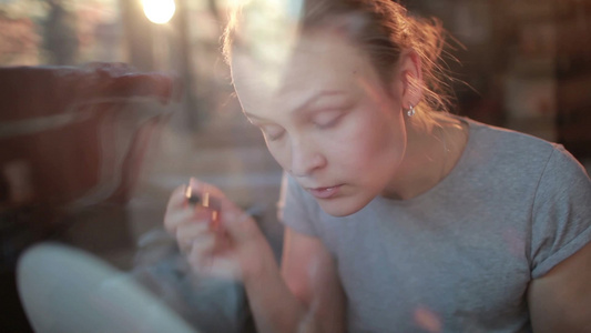 透过窗户看一个美丽的女孩在化妆视频