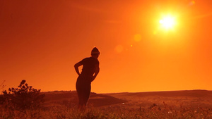 夕阳下年轻女子在田野里做热身运动8秒视频
