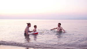 一家三口在日落的海边游泳嬉戏27秒视频