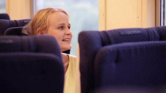 快乐的年轻女人乘火车旅行视频