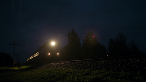 夜晚一列明亮的火车快速穿过农村地区的15秒视频