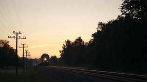 日落时分带着明亮前照灯的旅客列车在乡下慢慢地经过29秒视频