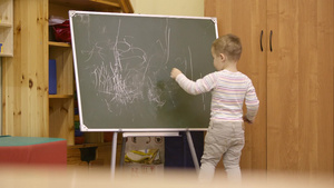 幼儿园的黑板上画画的小男孩10秒视频