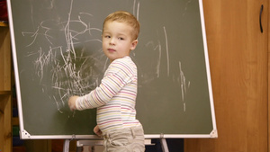 小男孩在幼儿园的教室里画黑板17秒视频