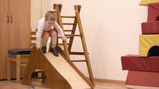 小男孩在室内滑滑梯上玩耍视频