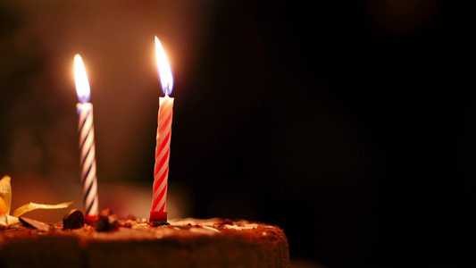 生日蛋糕上两支蜡烛在黑暗中燃烧视频