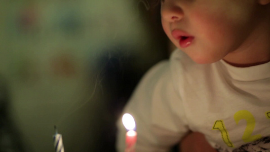 小男孩吹生日蛋糕的蜡烛视频