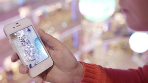 女人在智能手机里看圣诞树的照片9秒视频