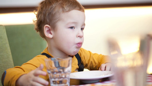 小男孩在咖啡馆的桌子上吃饭21秒视频