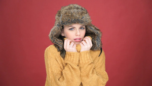 女人戴着一顶温暖的毛皮帽子她冷皱着眉头依偎在她温暖的脖子上11秒视频