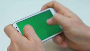 双手拿着智能手机玩绿色屏幕游戏22秒视频