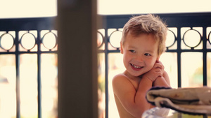 夏日阳台上可爱的微笑男孩10秒视频