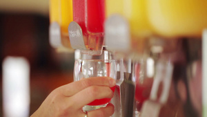女性拿着玻璃杯在果汁机里倒出饮料12秒视频
