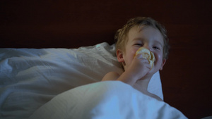 小男孩在床上吃面包看电视10秒视频
