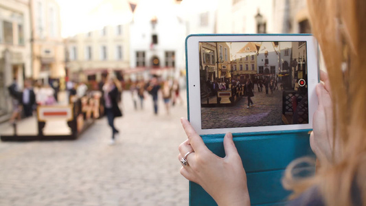 妇女使用平板电脑制作爱沙尼亚塔林古街视频的特写镜头视频