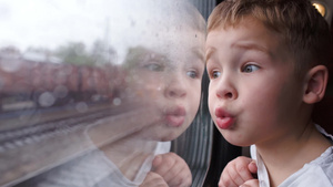 一个好奇的小男孩在火车上看着窗外11秒视频